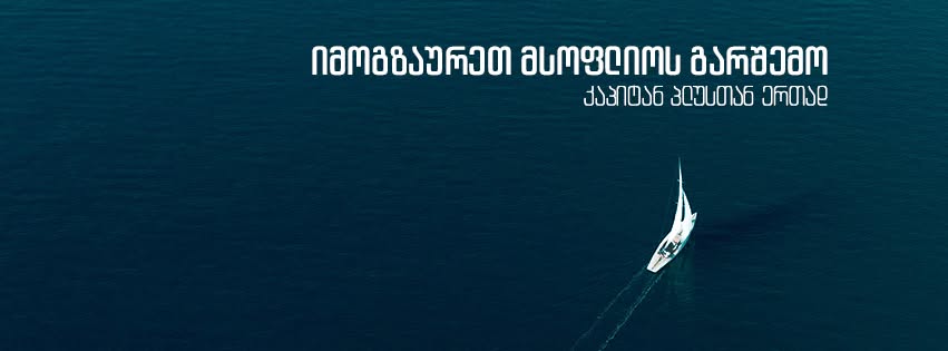 თეთრი აფრიანი იახტა მუქ ლურჯ ზღვაში, ხედი ზემოდან.