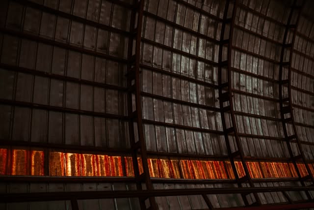 Warm light glowing through the slatted roof of an old festival venue