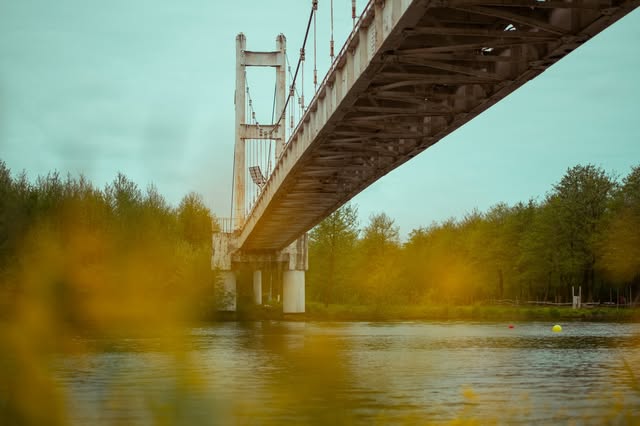 Suspension bridge arcing over Golden Lake at dusk in Poti